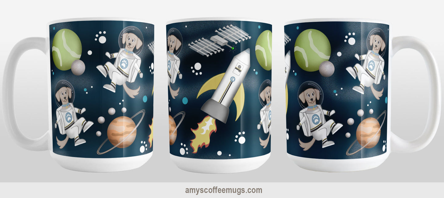 Galaxy Dog-stronaut Mug (15oz) at Amy's Coffee Mugs. A ceramic coffee mug with a fun galaxy "dog-stronaut" design with dog astronauts, dog themed planets, a dog bone satellite, paw print stars, and a dog branded rocket ship on an outer-space background. Perfect for people who love galaxy and space designs, and love dogs too! Image shows 3 views of the mug so you can see all sides of the printed design.