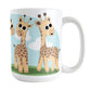 Gathering Giraffes Mug (15oz) at Amy's Coffee Mugs. A ceramic coffee mug designed with five cute illustrated giraffes, with different expressions, around the mug, over a blue sky and green grass background.