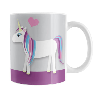 Happy Pink Heart Purple Unicorn Mug (11oz) at Amy's Coffee Mugs. A ceramic coffee mug designed with a happy unicorn with a pink, blue, and purple mane and a pink heart above it over purple and gray background that wraps around the mug up to the handle.