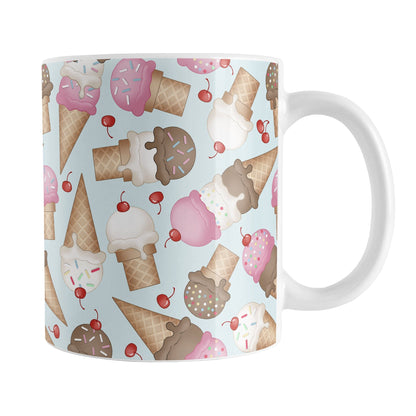 Ice Cream Cones Pattern Mug (11oz) at Amy's Coffee Mugs. A ceramic coffee mug printed with a design of hand-drawn ice cream cones with chocolate, strawberry, and vanilla scoops, with sprinkles and cherries, over a pale blue color, in a pattern that wraps around the mug to the handle.