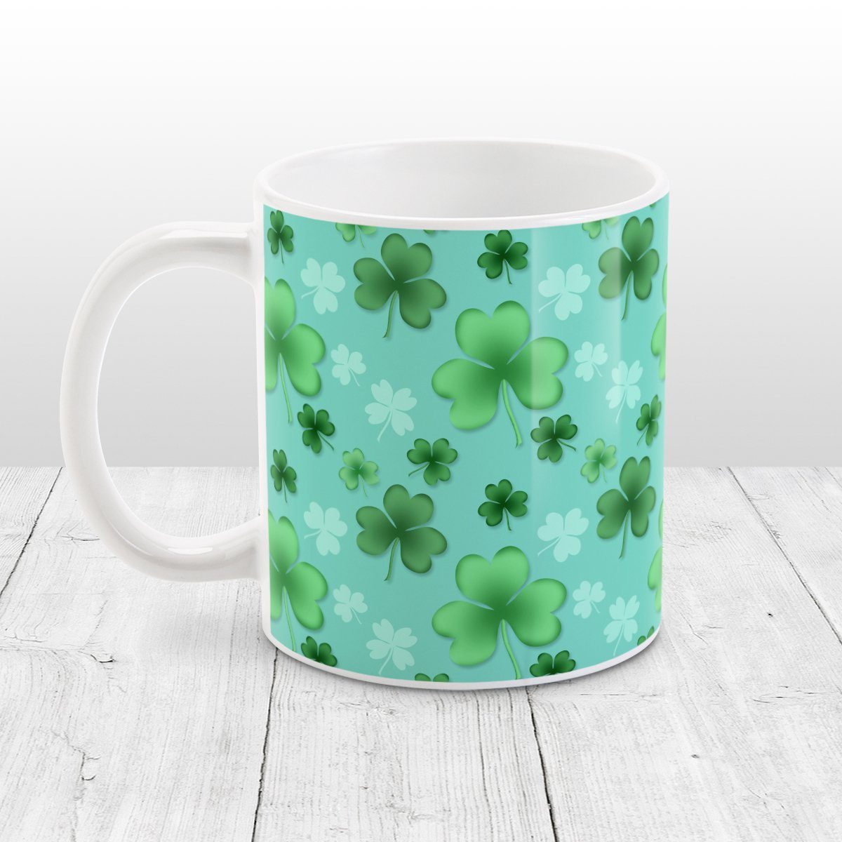 Clover Mug - St Patrick's Day - Lucky Clover Pattern Teal and Green - Clover Mug at Amy's Coffee Mugs. A ceramic coffee mug designed with a lucky green clover pattern with a 4-leaf clover among 3-leaf clovers, in different shades of green, over a teal background that wraps around the mug to the handle.