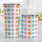 Orange Teal Pink Pumpkin Pattern Tumbler Cup (20oz and 10oz, stainless steel insulated) at Amy's Coffee Mugs. A tumbler cup designed with orange, teal, and pink pumpkins over a delicate green vine and leaves in a pattern that wraps around the cup. Photo shows both sized cups on a table next to each other.