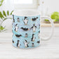 Penguin Parade Pattern Mug at Amy's Coffee Mugs. An 11oz ceramic coffee mug designed with a fun penguin parade pattern featuring a variety of penguins and baby penguins over an Antarctic background with waves of blue, turquoise, and purple colors with hints of snowflakes that wraps around the mug.