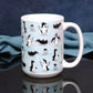 Penguin Parade Pattern Mug (15oz) on a glossy black tabletop with a midnight blue background.