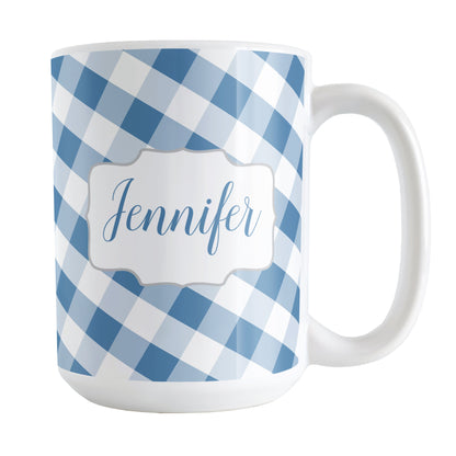 Personalized Blue Gingham Mug (15oz) at Amy's Coffee Mugs. A ceramic coffee mug designed with a slanted blue and white gingham pattern that wraps around the mug up to the handle. Your personalized name is custom-printed in a blue script font on both sides of the mug over the gingham pattern.