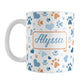 Personalized Blue Hearts and Paw Prints Mug (11oz) at Amy's Coffee Mugs. A ceramic coffee mug designed with a pattern of hearts and paw prints in orange and different shades of blue that wraps around the mug to the handle. Your name is personalized in a blue script font on both sides of the mug.