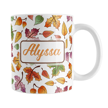 Personalized Changing Leaves Fall Mug (11oz) at Amy's Coffee Mugs. A ceramic coffee mug designed with a fall themed pattern of leaves changing colors, as they do at the beginning of autumn, that wraps around the mug. Your personalized name is custom printed in an orange script font on both sides of the mug over the leaves pattern.