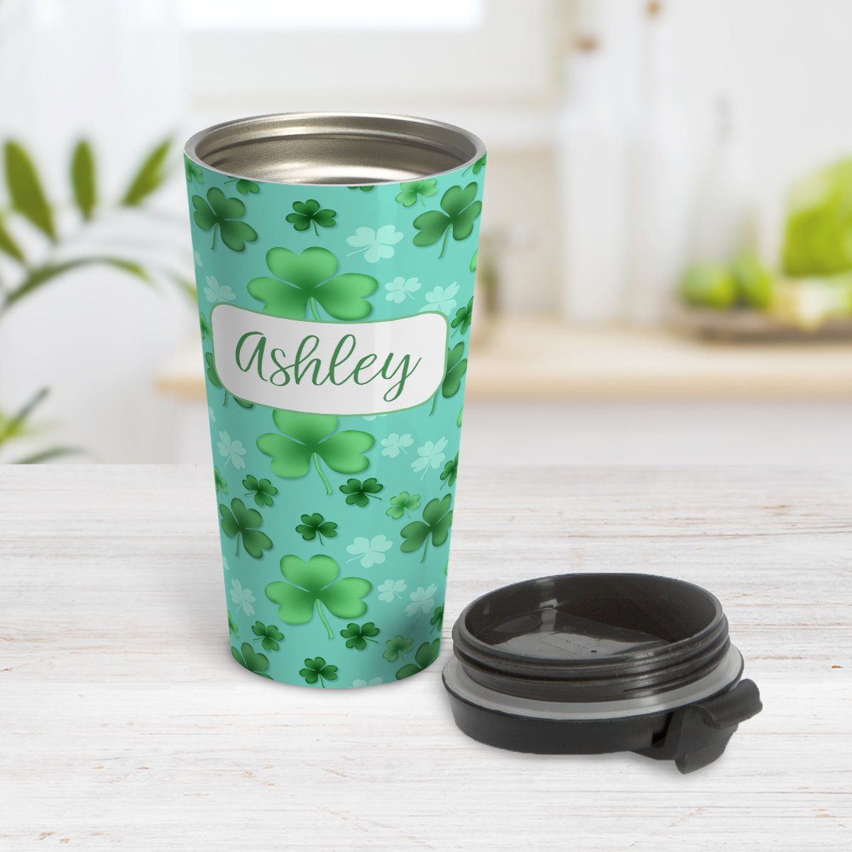 Personalized Lucky Clover Pattern Teal and Green Travel Mug at Amy's Coffee Mugs. A travel mug designed with a lucky green clover pattern with a 4-leaf clover among 3-leaf clovers, in different shades of green, over a teal background that wraps around the mug. Your name is personalized in green on white, over the lucky clover pattern.