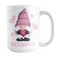 Personalized Pink Heart Gnome Mug (15oz) at Amy's Coffee Mugs. A ceramic coffee mug designed with an illustration of an adorable gnome with a pink pointed hat, holding a big pink heart, with light pink hearts around it. Below the gnome is your personalized name custom printed in a cute pink font. This charming gnome and personalized name are printed on both sides of the mug.