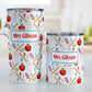 Personalized School Pattern Tumbler Cups (20oz or 10oz) at Amy's Coffee Mugs. Stainless steel tumbler cups designed with a school-themed pattern with apples, rulers, erasers, graded papers, numbers, and letters that wraps around the cups. Your personalized name or your teacher's name is custom printed in red over the school pattern. Photo shows both sized cups on a table next to each other.