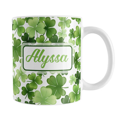 Personalized Shamrocks and 4-Leaf Clovers Mug (11oz) at Amy's Coffee Mugs. A ceramic coffee mug designed with an organic-like pattern of green shamrocks and 4-leaf clovers in different shades of green and is personalized with your name in green on both sides of the mug. This illustrated shamrocks pattern is printed around the mug up to the handle.
