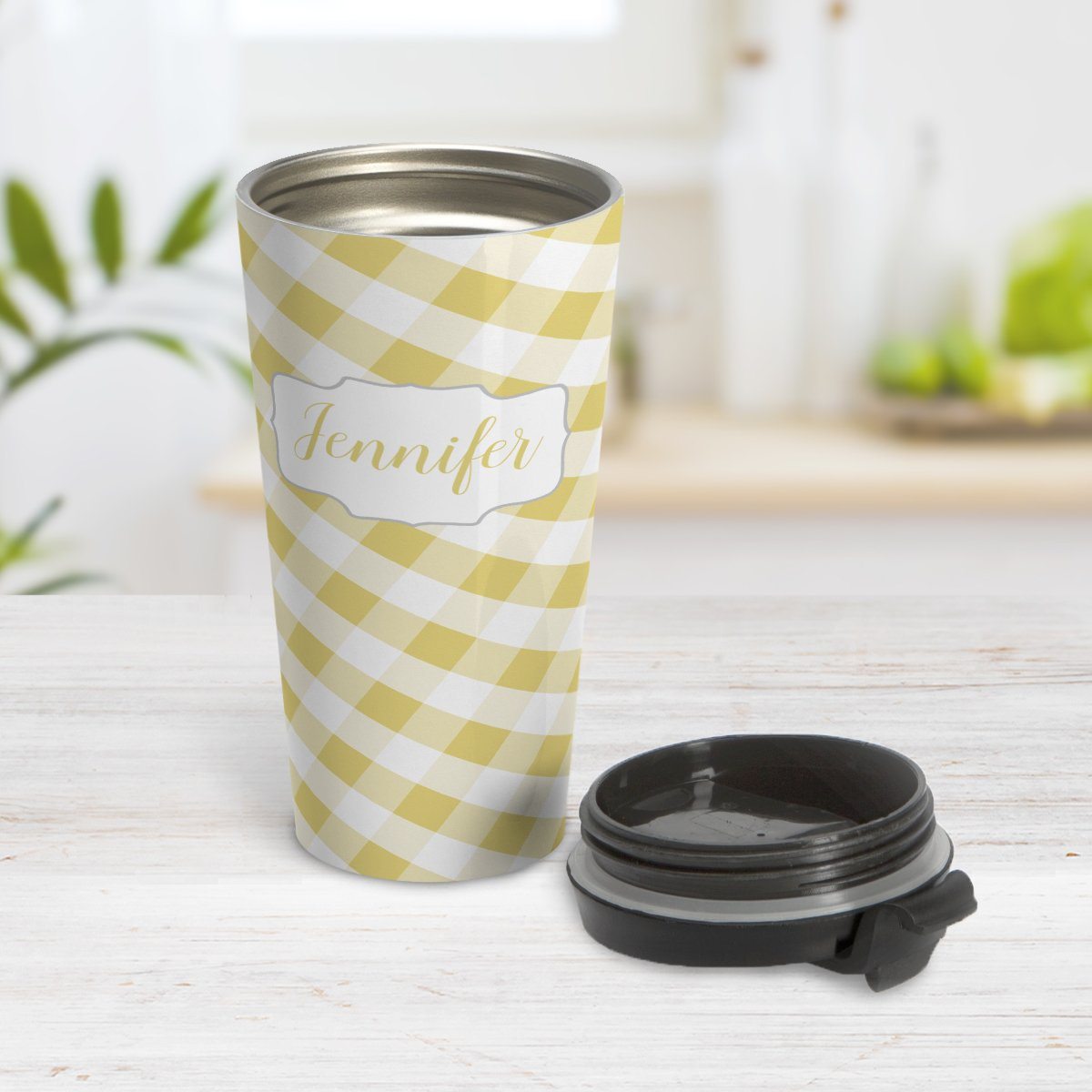 Personalized Yellow Gingham Travel Mug at Amy's Coffee Mugs. A travel mug designed with a slanted yellow and white gingham pattern that wraps around the travel mug. Your personalized name is custom-printed in a yellow script font in a white frame design over the gingham pattern. Photo shows the mug open on a table with its lid beside it.