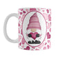 Pink Gnome Hearts Mug (11oz) at Amy's Coffee Mugs. A ceramic coffee mug designed with an adorable pink gnome in a white oval on both sides of the mug over a pattern of cute hearts in different shades of pink that wrap around the mug to the handle.