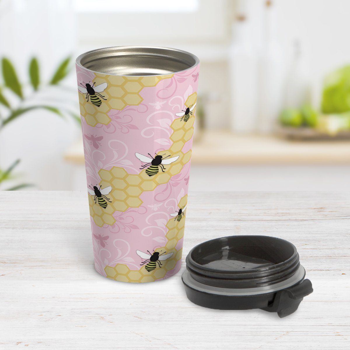 Pink Honeycomb Bee Travel Mug at Amy's Coffee Mugs. A travel mug designed with a pattern of black and yellow bees on honeycomb lines over a pink flourish background that wraps around the tapered shaped mug.