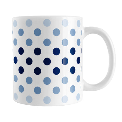Polka Dots in Blue Mug (11oz) at Amy's Coffee Mugs. A ceramic coffee mug designed with polka dots in different shades of blue, with the darker blue color across the middle and the lighter blue along the top and bottom, in a pattern that wraps around the mug to the handle. 