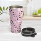 Puppy Run Pink Dog Travel Mug (15oz) at Amy's Coffee Mugs. A stainless steel travel mug designed with a pattern of chaotic tracks of puppy paw prints running around the mug with white dog bones, balls, and hearts over a light pink background. This mug is perfect for people who love the chaotic play of puppies, love dogs, and like pink travel mugs. Photo shows the open travel mug with the lid on the table beside it. 
