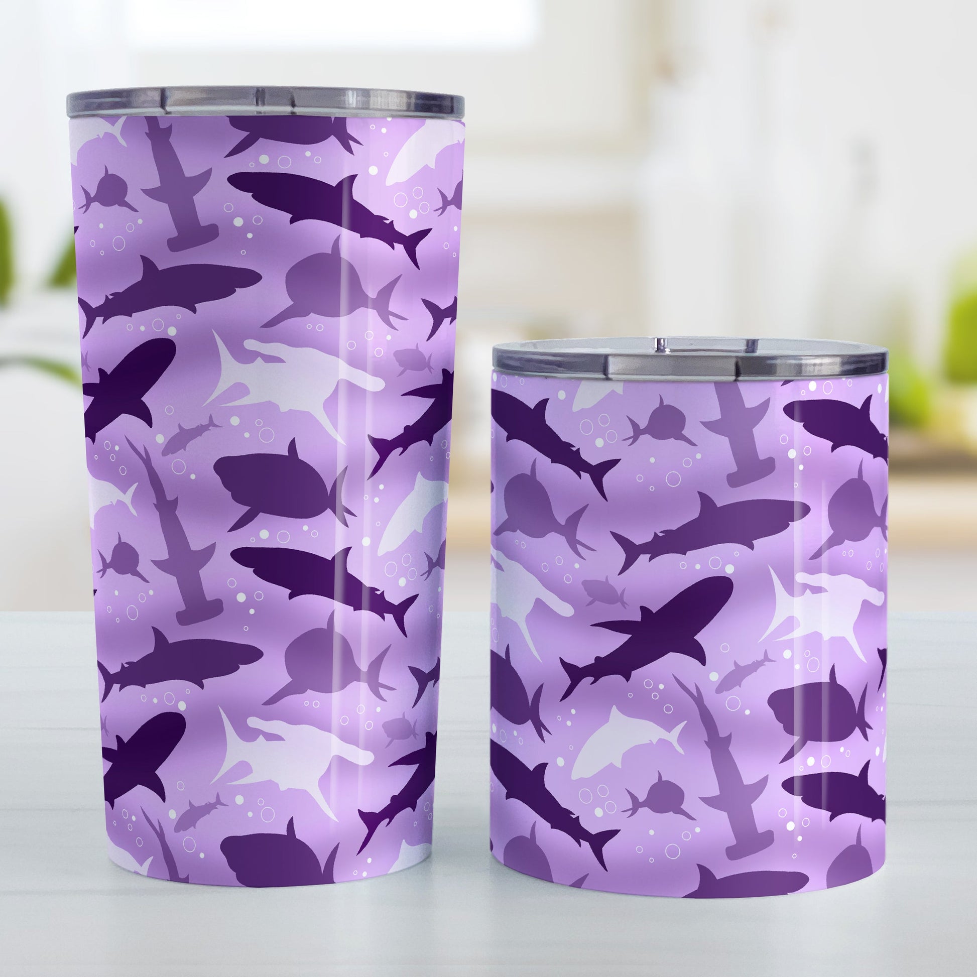 Purple Frenzy Sharks Tumbler Cup (20oz and 10oz) at Amy's Coffee Mugs. Stainless steel insulated tumbler cups designed with a pattern of sharks in different shades of purple, in a frenzy deep beneath the water, that wraps around the cups. Perfect for people who love sharks or are looking for the perfect shark gift. Photo shows both sized cups next to each other.