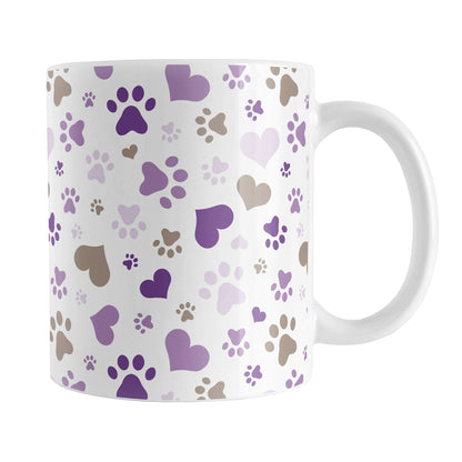 Purple Hearts and Paw Prints Mug (11oz) at Amy's Coffee Mugs. A ceramic coffee mug designed with a pattern of hearts and paw prints in brown and different shades of purple that wraps around the mug to the handle. This mug is perfect for people love dogs and cute paw print designs.