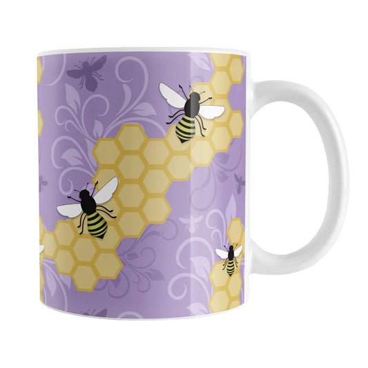 Purple Honeycomb Bee Mug (11oz) at Amy's Coffee Mugs. A ceramic coffee mug designed with a pattern of black and yellow bees on honeycomb lines over a purple flourish background that wraps around the mug to the handle.