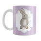 Rustic Purple Rabbit Mug (11oz) at Amy's Coffee Mugs. A ceramic coffee mug designed with a watercolor inspired illustration of a brown bunny rabbit in a white frame area outlined in purple and blue, over a rustic purple background that wraps around the mug to the handle. This bunny illustration is on both sides of this purple rabbit mug.