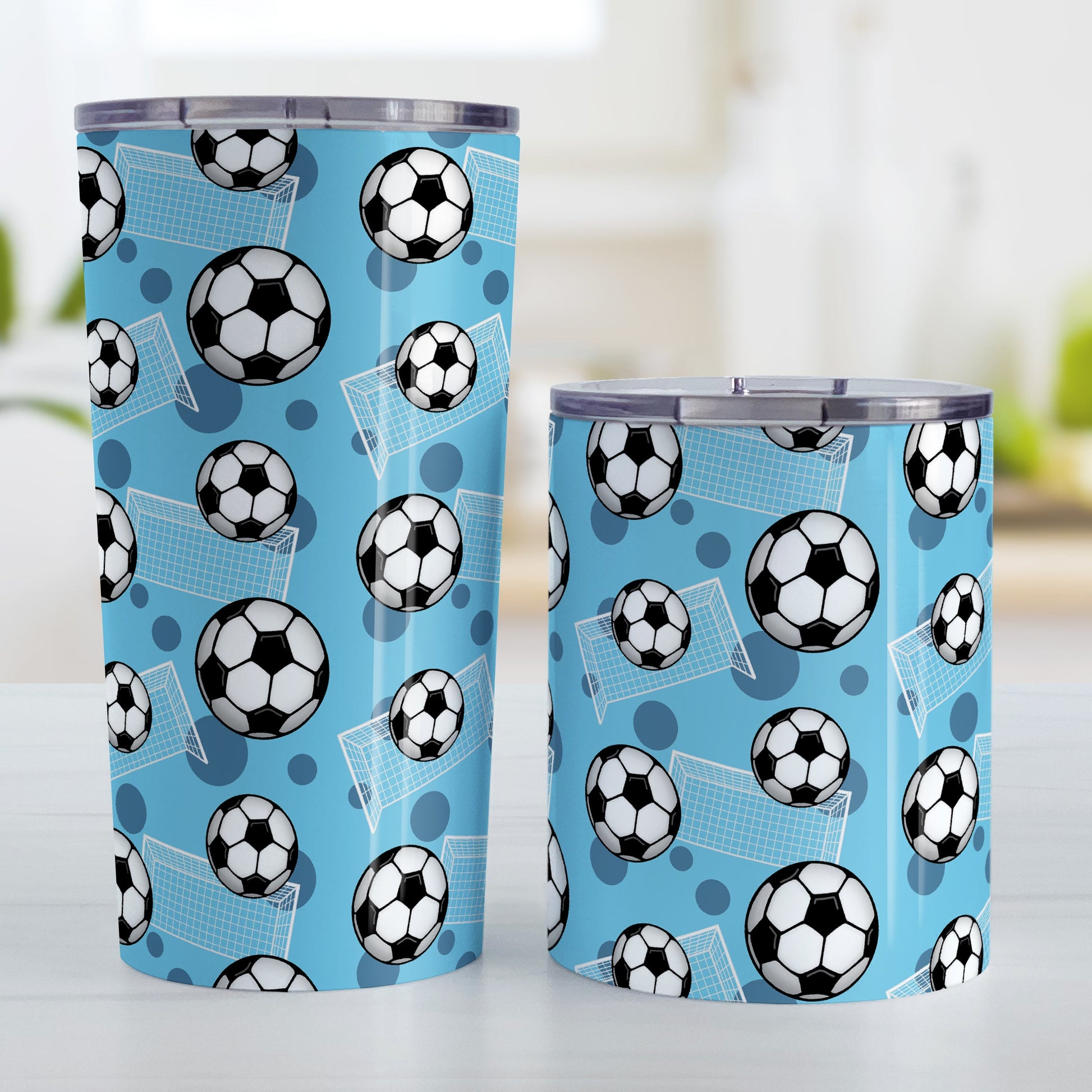 Soccer Ball and Goal Pattern Blue Tumbler Cup (20oz and 10oz) at Amy's Coffee Mugs. Stainless steel insulated tumbler cups designed with a pattern of soccer balls and goals over a blue background that wraps around the cups. These blue soccer tumbler cups are perfect for people who love or play soccer. Photo shows both sized cups next to each other.