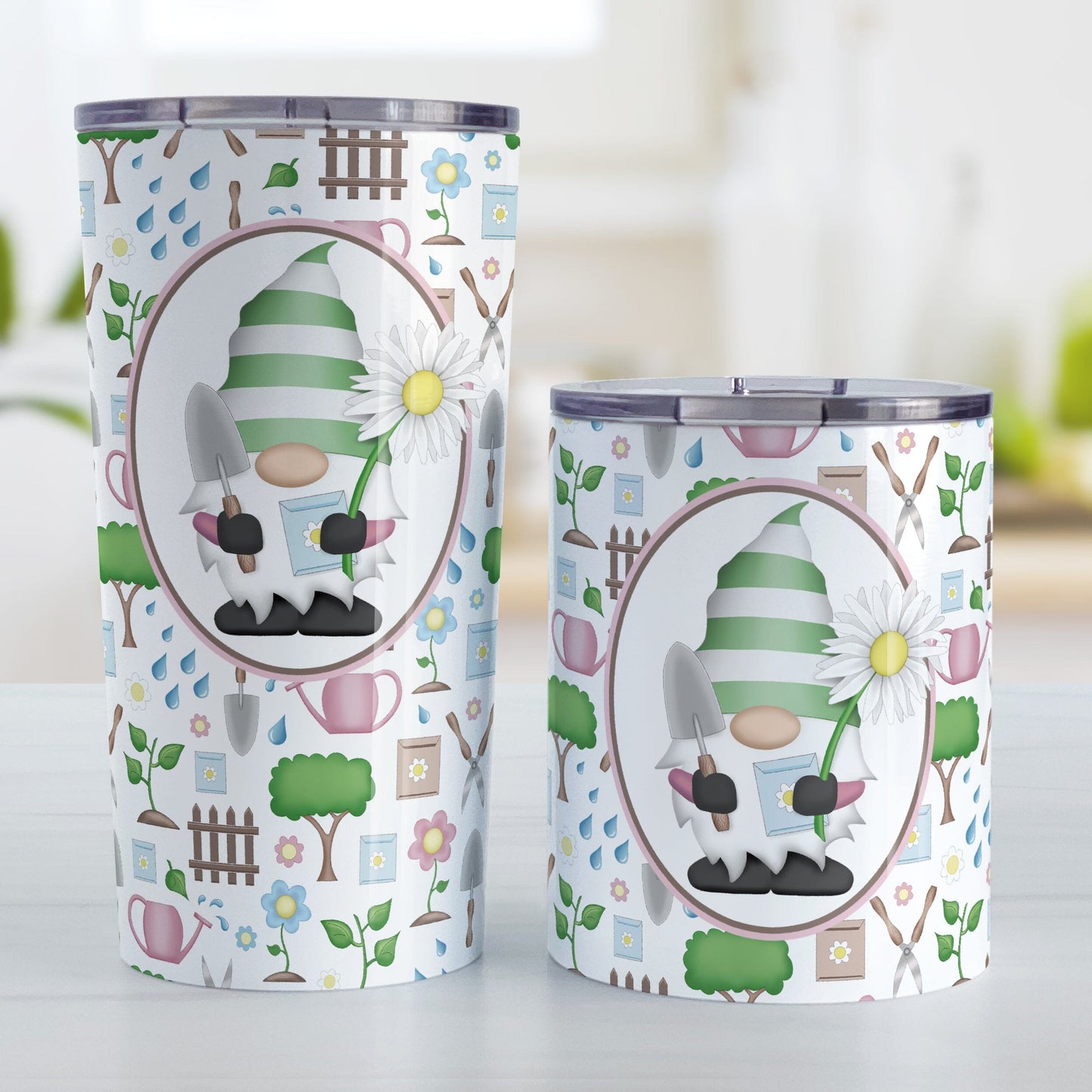 Spring Gnome Gardening Pattern Tumbler Cups (20oz or 10oz) at Amy's Coffee Mugs. Stainless steel tumbler cups designed with an adorable spring gardening gnome holding an oversized daisy in a white oval over a springtime gardening pattern with trees, plants, flowers, seed packets, watering cans, fences, and gardening tools in spring colors such as pink, blue, green, and brown. Photo shows both sized cups next to each other on a table.