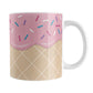 Strawberry Ice Cream Waffle Cone Mug (11oz) at Amy's Coffee Mugs. A ceramic coffee mug with a yummy looking dessert illustration of pink strawberry ice cream with sprinkles atop a waffle cone pattern in a design that wraps around the mug up to the handle.