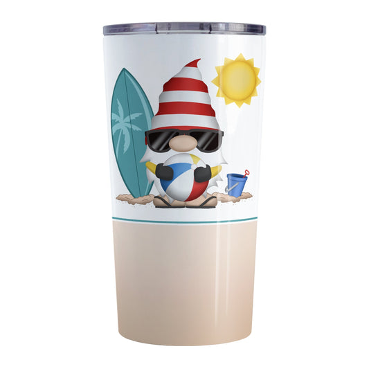 Summer Beach Gnome Tumbler Cup (20oz) at Amy's Coffee Mugs. A stainless steel tumbler cup designed with an adorable gnome in sunglasses, holding a beach ball, with a surfboard and bucket in the sand on either side of him, and a bright yellow sun in the sky. Below the gnome is a sandy beige background color along the bottom of the cup.
