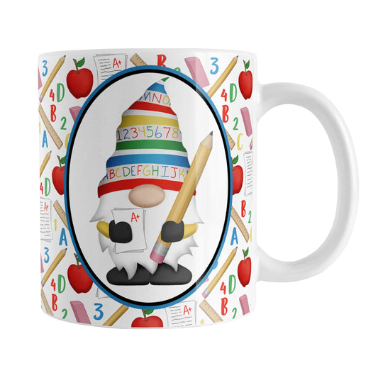 Teacher Gnome School Pattern Mug (11oz) at Amy's Coffee Mugs. A ceramic coffee mug designed with an illustration of an adorable gnome wearing a festive hat with numbers and letters in primary colors and holding a large oversized pencil and graded A+ paper inside an oval. This cute gnome design is on both sides of the mug over a school-themed pattern that wraps around the mug to the handle with apples, rulers, erasers, graded papers, numbers, and letters. 
