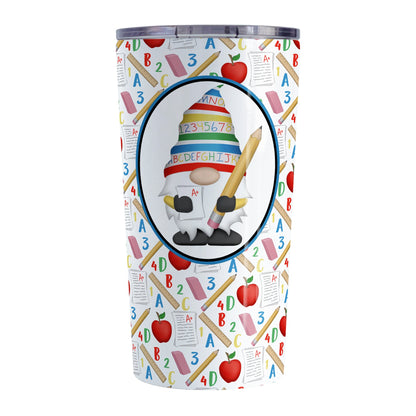 Teacher Gnome School Pattern Tumbler Cup (20oz) at Amy's Coffee Mugs. A stainless steel tumbler cup designed with an illustration of an adorable gnome wearing a festive hat with numbers and letters in primary colors and holding a large oversized pencil and graded A+ paper inside an oval. This cute gnome oval is placed over a school-themed pattern that wraps around the cup with apples, rulers, erasers, graded papers, numbers, and letters.