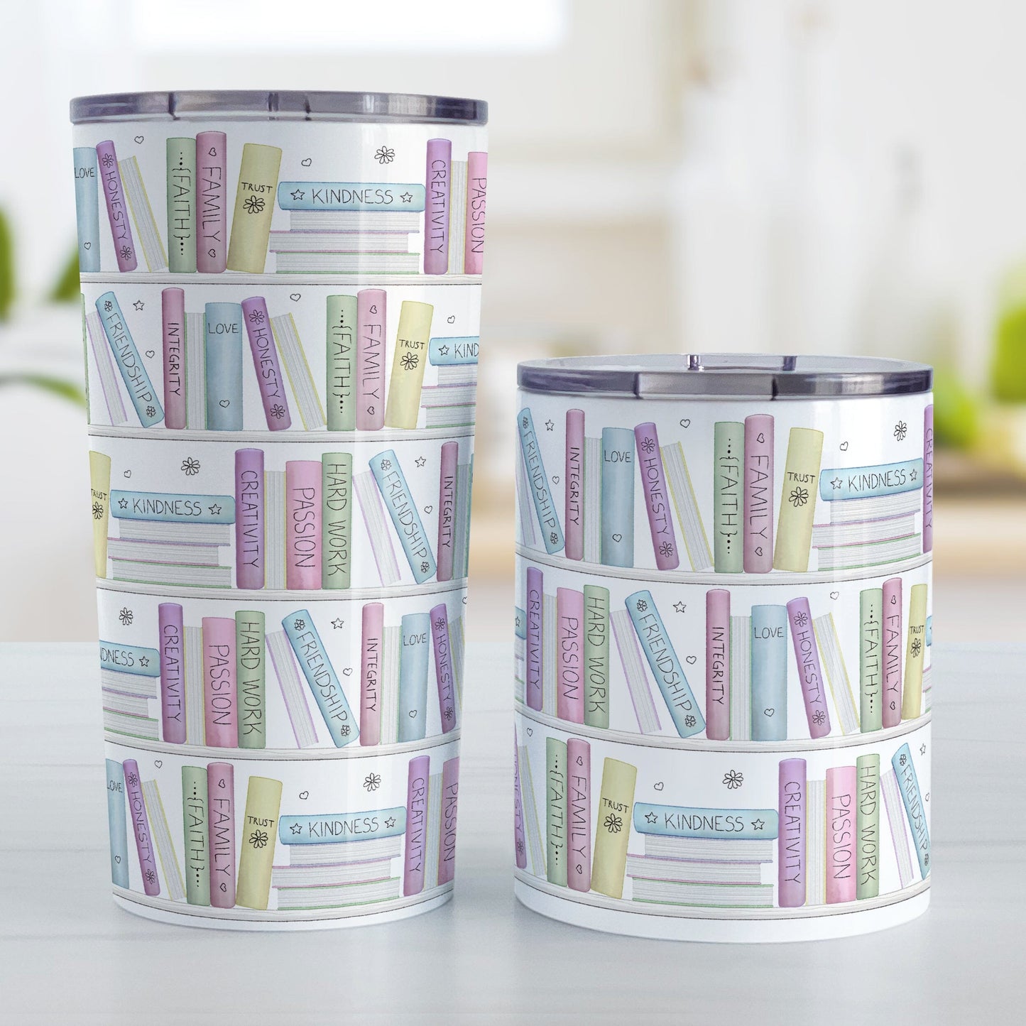 The Building Books of Life - Inspirational Reading Tumbler Cups (20oz or 10oz) at Amy's Coffee Mugs. Stainless steel tumbler cups designed with a colorful pattern of books on a bookshelf each with an inspirational title that all could be considered important building blocks of life, such as love, family, integrity, passion, faith, creativity, and more. Photo shows both sized cups on a table next to each other.