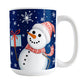 Winter Snowman Mug (15oz) at Amy's Coffee Mugs. A ceramic coffee mug designed with an illustration of a happy snowman wearing a red scarf and hat, while holding a blue gift box, over a winter night sky background with snowflakes around him.