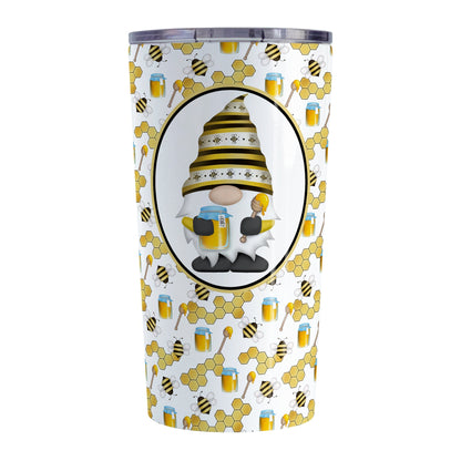 Yellow Gnome Honey Jar Bee Tumbler Cup (20oz) at Amy's Coffee Mugs. A stainless steel tumbler cup designed with an adorable gnome wearing a yellow bee-themed hat and holding a honey jar and honey dipper in a white oval over a pattern background that wraps around the cup with bees, honey jars, honey dippers, and honeycomb.